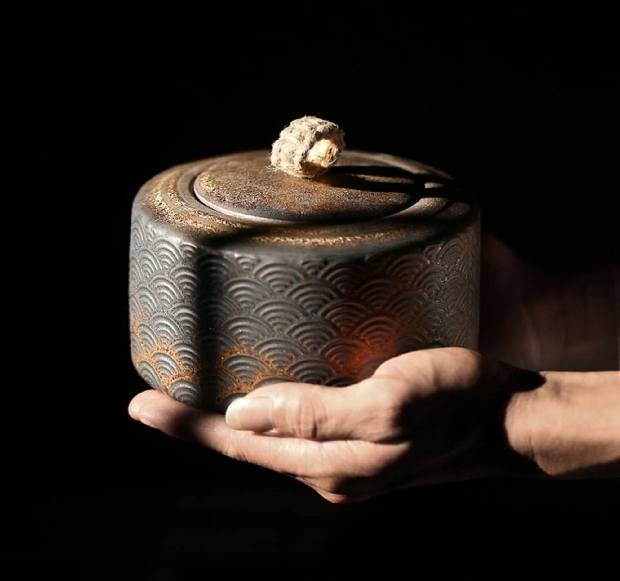 Vintage kitchen canister with Japanese wave pattern, held in hand.